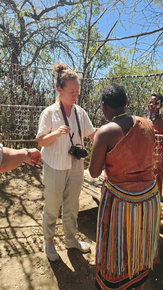 Guest choosing hand-made beadwork from a Datoga woman at her homestead
